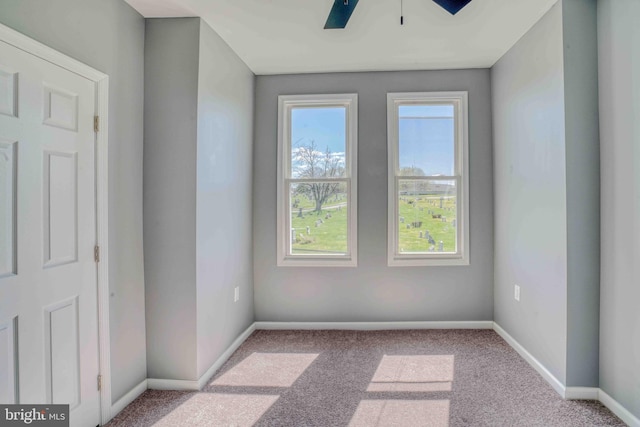 unfurnished room featuring carpet floors, baseboards, and ceiling fan