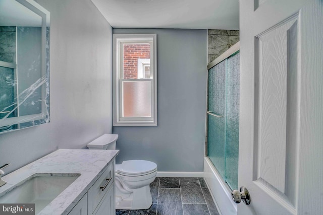 bathroom with combined bath / shower with glass door, toilet, vanity, and baseboards