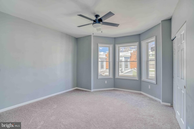 unfurnished bedroom with ceiling fan, carpet flooring, and baseboards