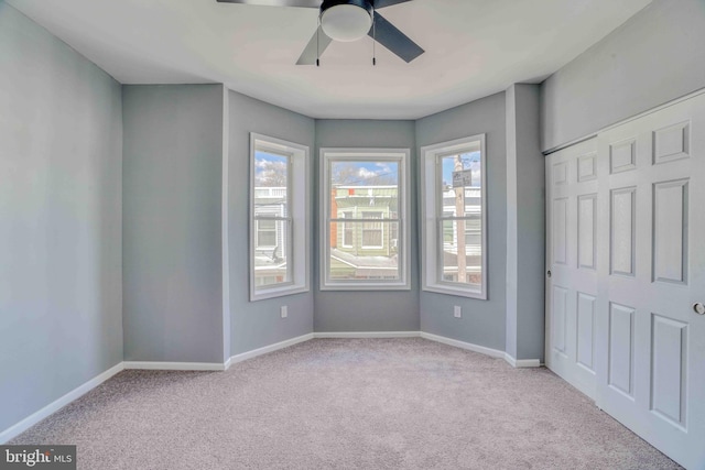 unfurnished bedroom with carpet floors, baseboards, and a ceiling fan