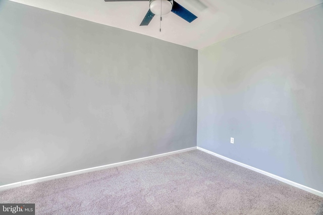carpeted empty room with ceiling fan and baseboards