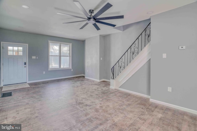 unfurnished living room with visible vents, baseboards, ceiling fan, stairway, and wood finished floors