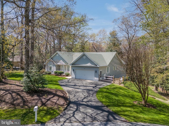 ranch-style home featuring an attached garage, aphalt driveway, and a front lawn