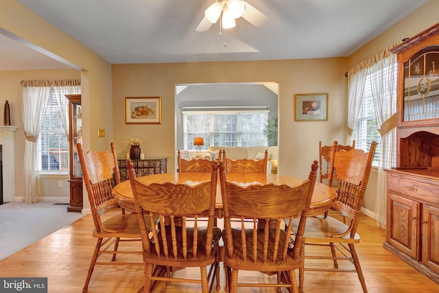dining space featuring light wood-style flooring, ceiling fan, and baseboards