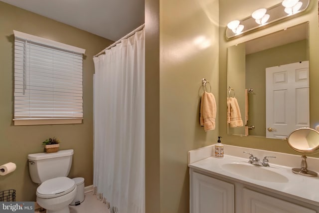 bathroom with toilet, curtained shower, and vanity
