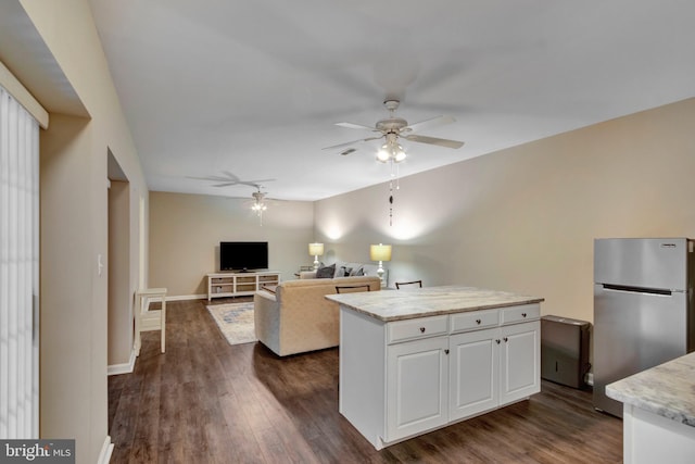 living area featuring dark wood-style flooring, ceiling fan, and baseboards