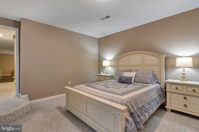 bedroom with visible vents, baseboards, and light carpet