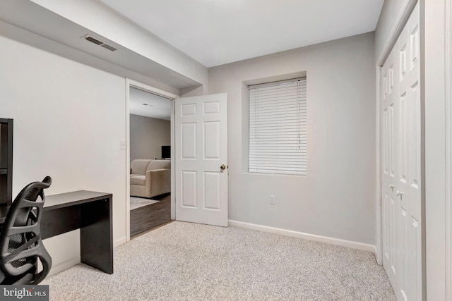 home office with visible vents, baseboards, and light colored carpet