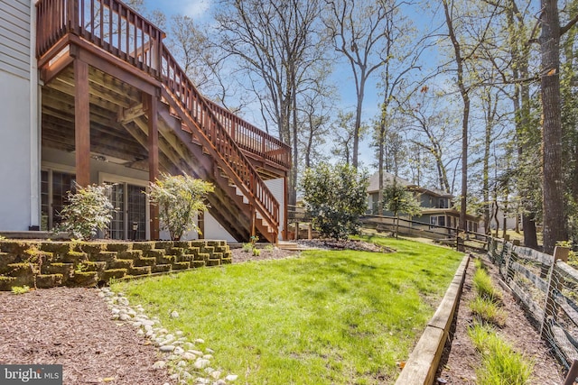 view of yard with stairway, a wooden deck, and fence
