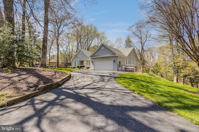 view of front of home featuring an attached garage, driveway, and a front lawn