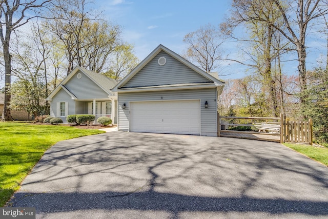 view of front facade with aphalt driveway, an attached garage, fence, and a front lawn