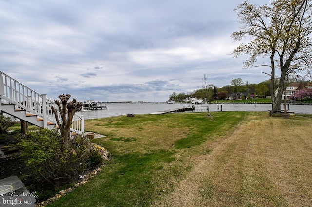 view of yard featuring a boat dock and a water view