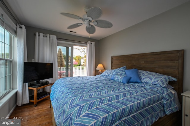 bedroom with access to outside, ceiling fan, visible vents, wood finished floors, and baseboards