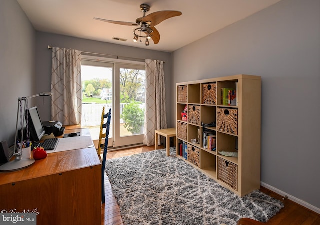 office area with visible vents, ceiling fan, wood finished floors, and baseboards