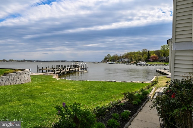 view of dock with a water view and a yard