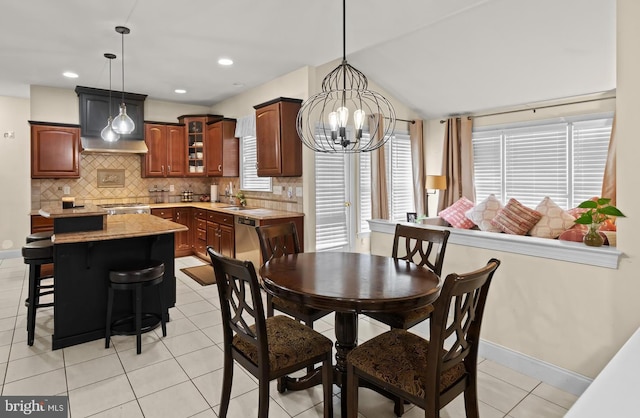 dining room with baseboards, light tile patterned flooring, a chandelier, and lofted ceiling