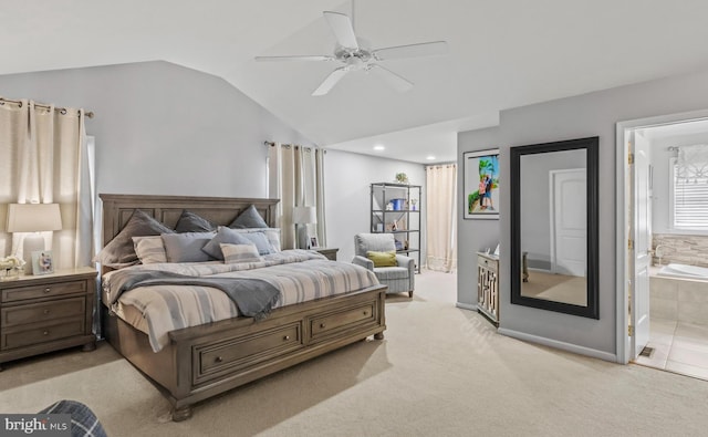 bedroom featuring vaulted ceiling, baseboards, light carpet, and ensuite bathroom