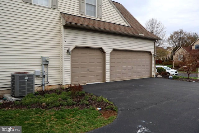 garage with cooling unit and aphalt driveway