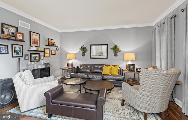 living room featuring visible vents, wood finished floors, baseboards, and ornamental molding