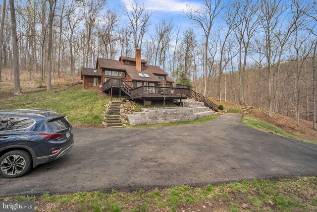 38528 Lime Kiln Rd, Middleburg, VA 20117 - view of front of house with a deck, a chimney, stairway, a forest view, and a front lawn