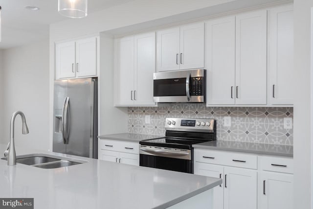 3393 Monterey Dr, Rockingham, VA 22801 - kitchen with white cabinets, a sink, light countertops, appliances with stainless steel finishes, and decorative backsplash