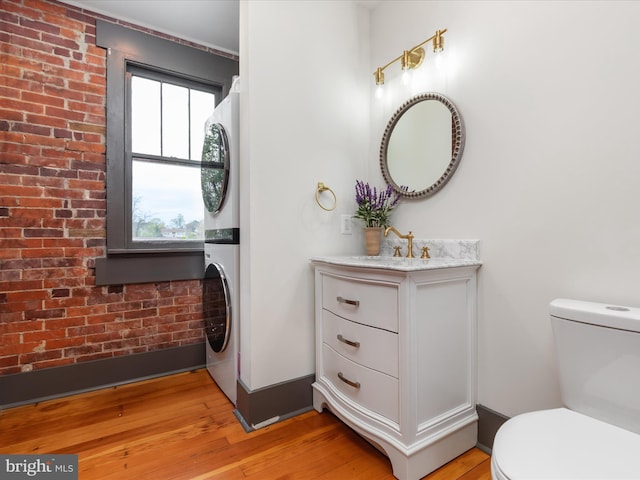 803 Berryville Ave, Winchester, VA 22601 - bathroom with toilet, vanity, hardwood / wood-style flooring, and stacked washer / drying machine