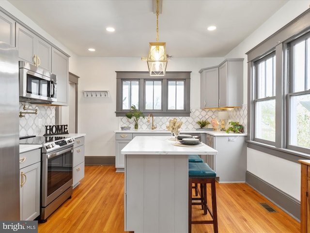 803 Berryville Ave, Winchester, VA 22601 - kitchen with a kitchen bar, visible vents, appliances with stainless steel finishes, gray cabinetry, and backsplash