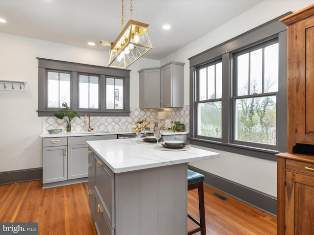 803 Berryville Ave, Winchester, VA 22601 - kitchen with decorative backsplash, a kitchen breakfast bar, gray cabinetry, and visible vents