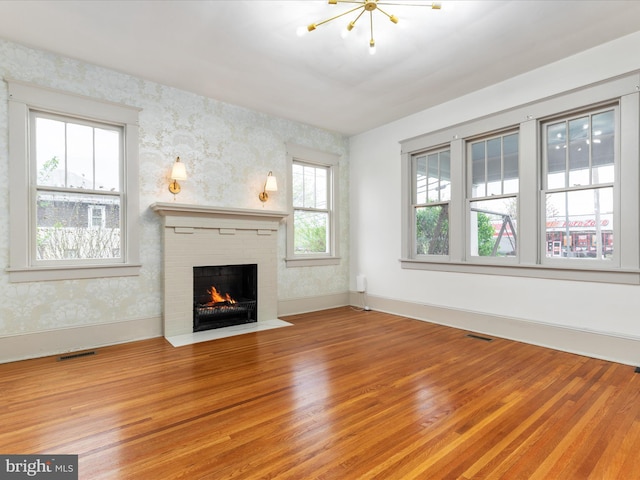 803 Berryville Ave, Winchester, VA 22601 - unfurnished living room with visible vents, a fireplace, light wood-style floors, and wallpapered walls