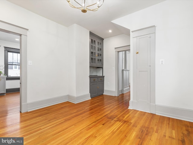 803 Berryville Ave, Winchester, VA 22601 - unfurnished living room featuring baseboards, recessed lighting, an inviting chandelier, and light wood-style floors