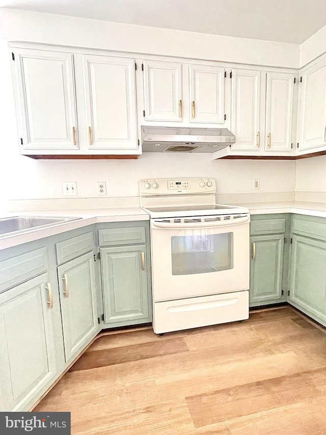 kitchen with light wood-style floors, under cabinet range hood, light countertops, and white range with electric cooktop