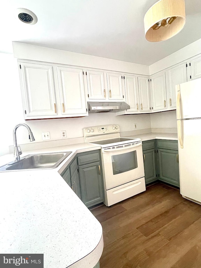 kitchen with white appliances, dark wood-type flooring, white cabinetry, under cabinet range hood, and a sink