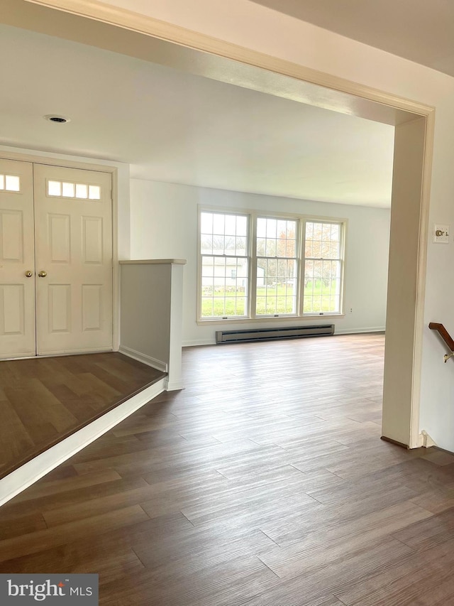 entrance foyer with a baseboard radiator, wood finished floors, baseboards, and plenty of natural light