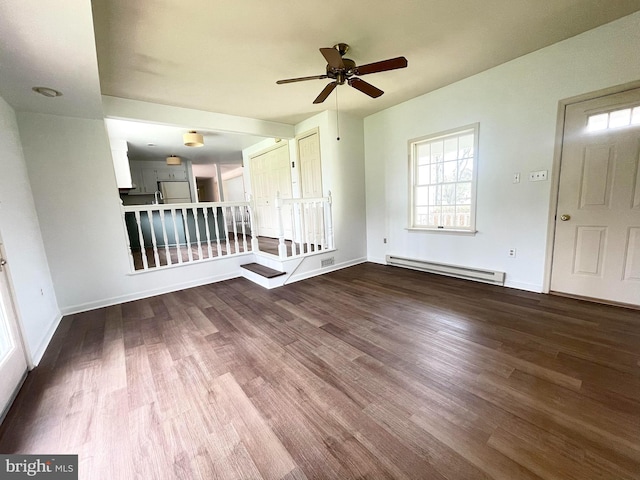 unfurnished room with ceiling fan, a baseboard radiator, baseboards, and wood finished floors