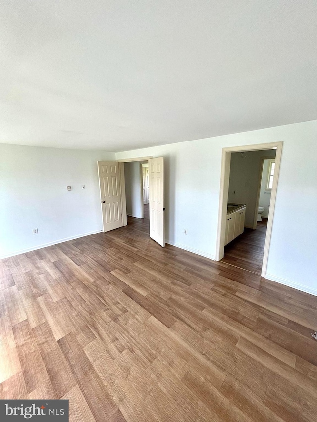 empty room featuring wood finished floors and baseboards