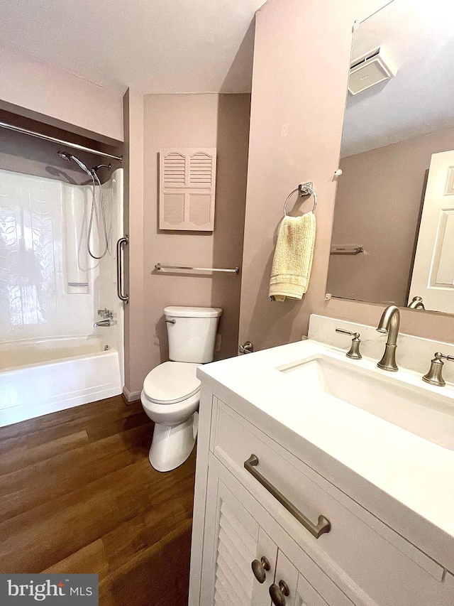 bathroom with toilet, shower / tub combination, vanity, and wood finished floors