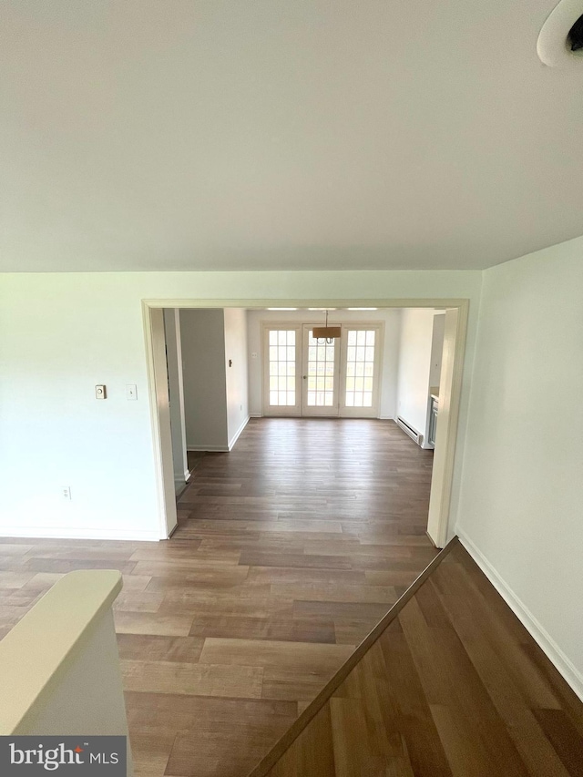 interior space featuring baseboards, a baseboard radiator, and wood finished floors