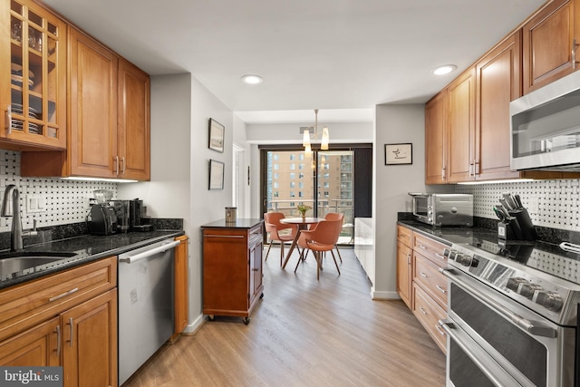 1530 Key Blvd Unit 528, Arlington, VA 22209 - kitchen featuring stainless steel appliances, a sink, a chandelier, light wood-style floors, and decorative backsplash