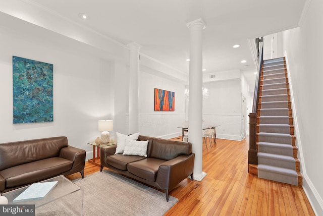 living room featuring recessed lighting, decorative columns, light wood-style floors, baseboards, and stairway