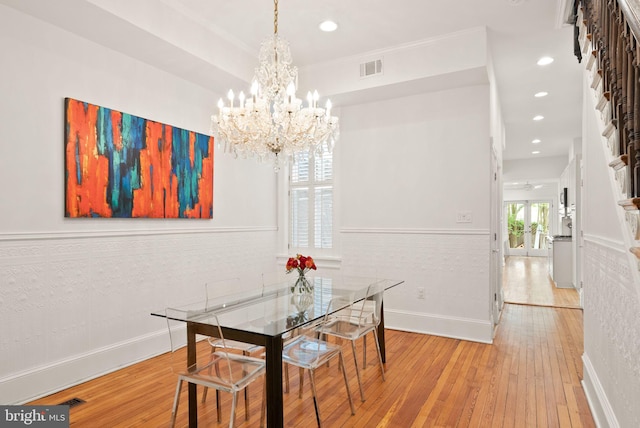 dining space featuring a wainscoted wall, a notable chandelier, recessed lighting, and wood-type flooring