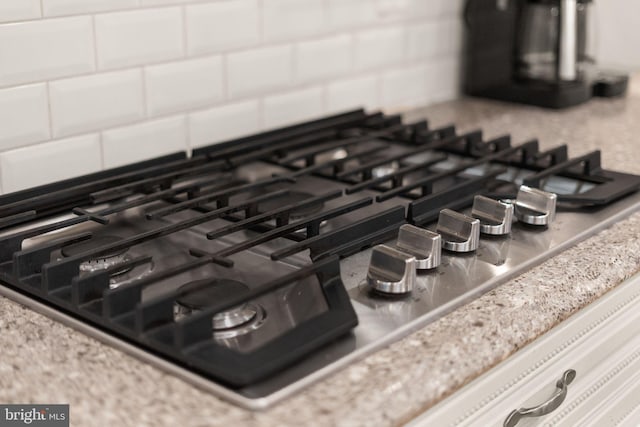 details featuring tasteful backsplash and stainless steel gas stovetop