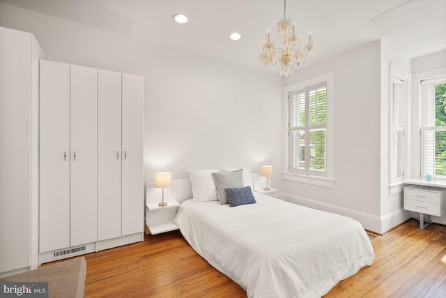 bedroom featuring a chandelier, recessed lighting, light wood finished floors, and baseboards