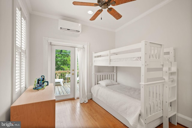 bedroom featuring a wall mounted air conditioner, access to outside, ornamental molding, and wood finished floors