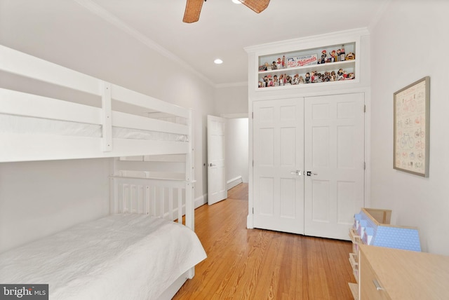 bedroom with light wood finished floors, recessed lighting, a closet, ceiling fan, and crown molding
