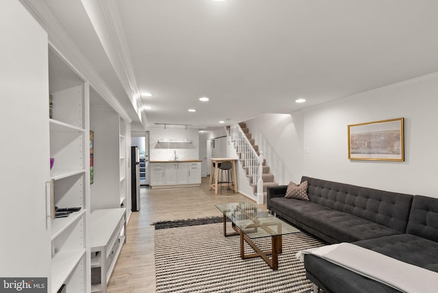living area with stairway, light wood-style floors, crown molding, and recessed lighting