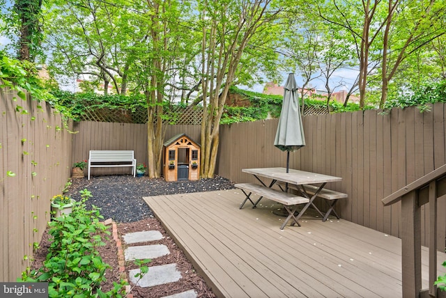 wooden terrace featuring outdoor dining area and a fenced backyard