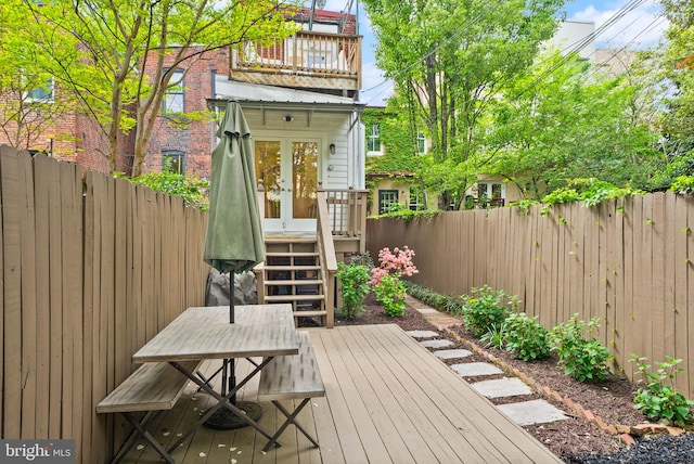 deck featuring outdoor dining area, french doors, and a fenced backyard