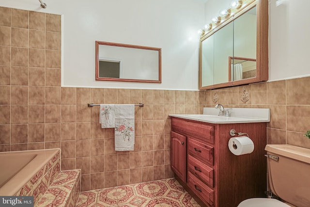 bathroom with tile walls, toilet, vanity, and wainscoting