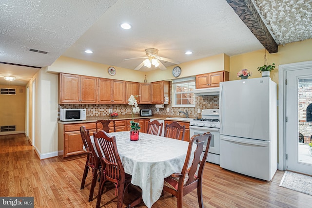 kitchen featuring visible vents, white appliances, and a textured ceiling