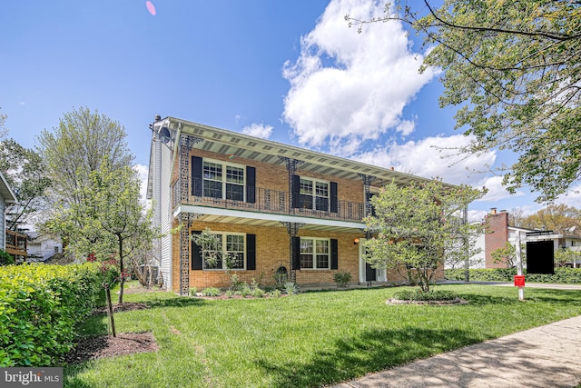view of front of property featuring a porch, brick siding, a front yard, and a balcony